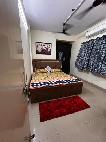 a bedroom with a bed and a red rug at Air deck luxury flat in Patna