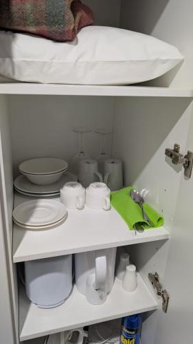 a closet with white dishes and a bed at MOTEL ROYAL TARA in Binalong
