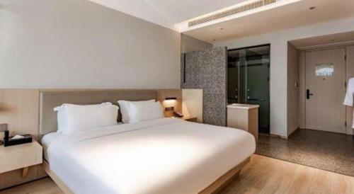 a large white bed in a hotel room at Airfeel Hotel in Ziyang