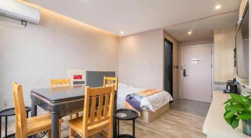 a bedroom with a bed and a table and a dining room at Shell Hotel Wuxi Huishan District Chang'an Town in Wuxi