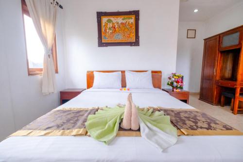 a bedroom with a bed with a towel on it at Teba House Ubud by ecommerceloka - CHSE Certified in Ubud