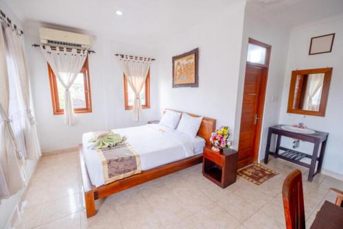 a bedroom with a white bed and a table at Teba House Ubud by ecommerceloka - CHSE Certified in Ubud