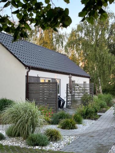 姆热日诺Apartamenty Słoneczna 18 Mrzeżyno的一座带栅栏和一些植物的白色房子