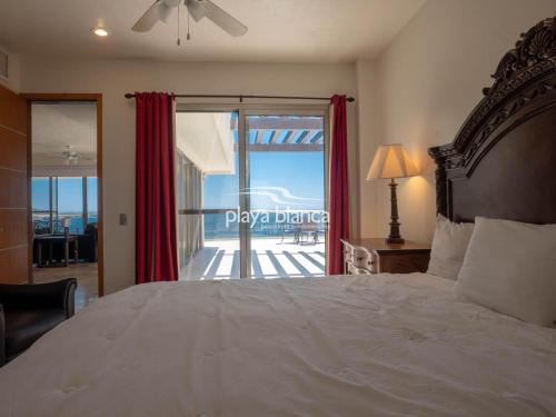 a bedroom with a bed and a view of the ocean at Playa Blanca Premier Unit 1410 in San Carlos