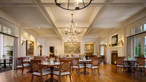 a dining room with tables and chairs and a chandelier at Signature 5 Bedroom Lagoon Residence 1003 in Bluffton