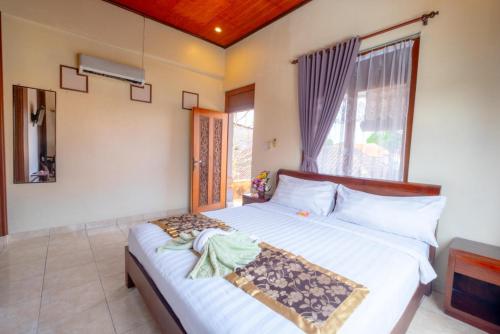 a bedroom with a bed and a large window at Teba House Ubud by ecommerceloka - CHSE Certified in Ubud