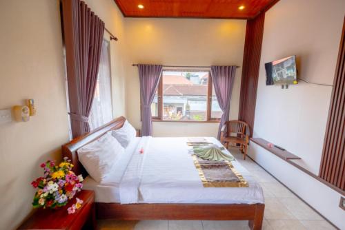a bedroom with a bed and a window at Teba House Ubud by ecommerceloka - CHSE Certified in Ubud