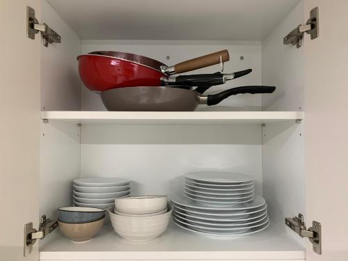 a kitchen shelf with plates and a bowl and a strainer at Lotte Tower view terrace house in Seoul
