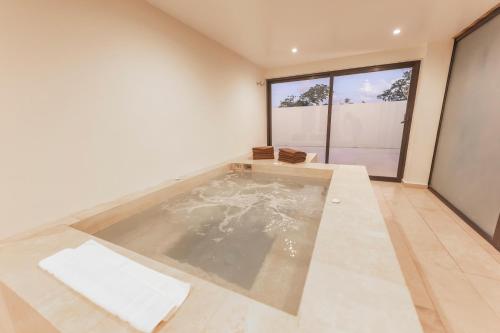 a swimming pool in a room with a large window at The Waves Tulum Secluded studio apartment with balcony in Tulum