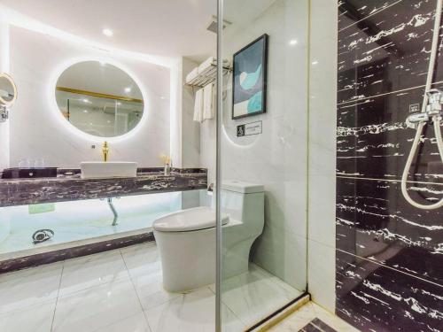 a bathroom with a toilet and a sink and a mirror at GEM Hotel Chengdu Chunxi Road Taiguli in Chengdu
