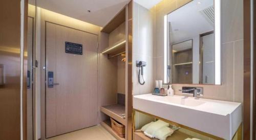 a bathroom with a white sink and a mirror at Lavande Hotel Guangzhou Quzhuang Metro Station in Guangzhou