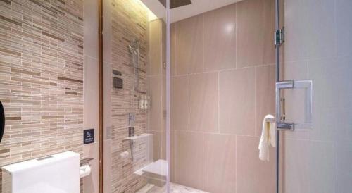 a bathroom with a shower with a toilet and a sink at Lavande Hotel Guangzhou Quzhuang Metro Station in Guangzhou