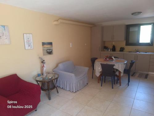 a living room with a table and chairs and a kitchen at Akrotirio Tainaro House in Marmari