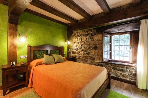 a bedroom with a bed with green walls and a window at Hotel Spa Casona La Hondonada in Terán