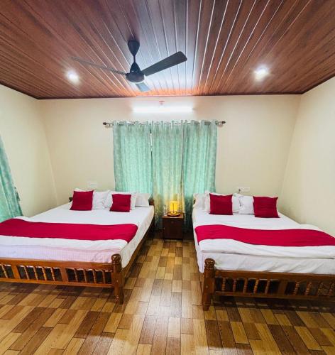 a bedroom with two beds and a ceiling at River Raga Nature Resort in Kārkāl