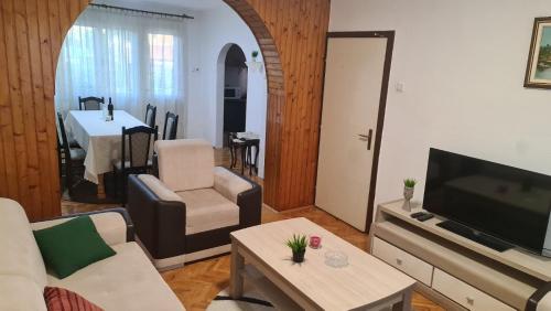 un soggiorno con un divano, una TV e un tavolo di Vila Marija a Sarajevo