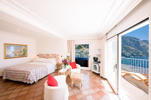 a hotel room with a bed and a balcony at Villa Anfitrite in Positano