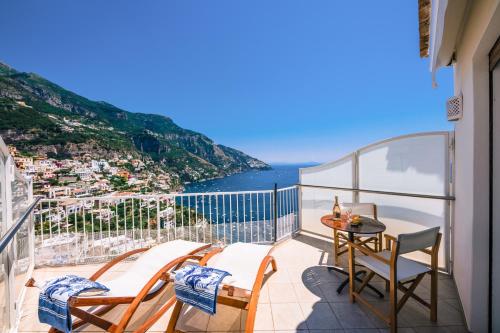 a balcony with chairs and a table and the ocean at Villa Anfitrite in Positano