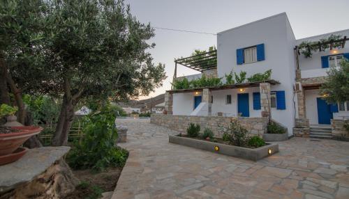 a house with blue doors and a stone courtyard at Brother's Hotel in Ios Chora