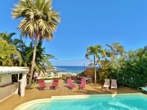 een zwembad met stoelen en uitzicht op de oceaan bij Villa Blue Waves in Saint-Gilles-les-Bains