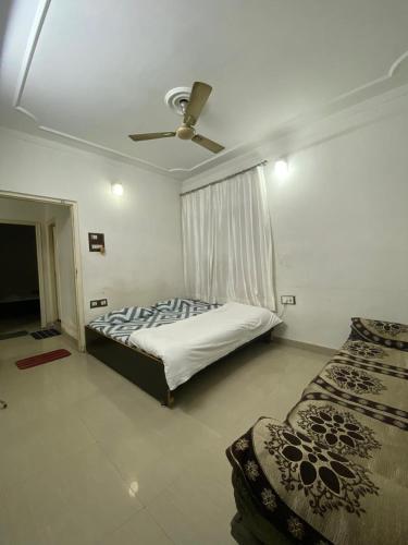 a bedroom with a bed and a ceiling fan at New Kashi darshan Family and group guest house in Varanasi
