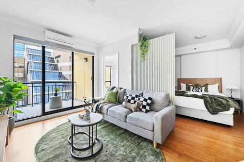 a living room with a couch and a bed at Skyline Stay Central 2 Bed Apartment in Perth