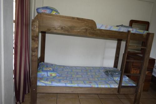 a bunk bed with a wooden frame and a bedsheet at Villas Maria Luisa in Uvita