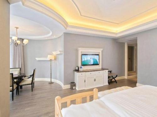 a bedroom with a bed and a table and a television at Yin Run Jin Jiang Castle Hotel in Huzhou