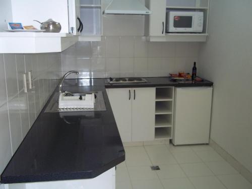 a kitchen with a black counter top and a microwave at Delfines Apart Hotel in La Paz