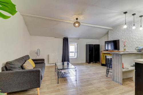 a living room with a couch and a table at Le nid douillet - Centre Ville - 3 étoiles in Bourg-en-Bresse