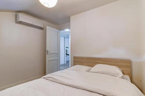 a bedroom with a bed with white sheets at Le nid douillet - Centre Ville - 3 étoiles in Bourg-en-Bresse