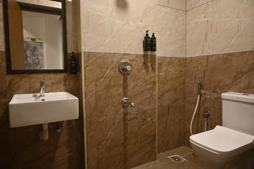 a bathroom with a shower and a toilet and a sink at The Dritan in Bengaluru