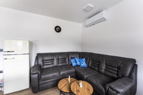 a living room with a black couch and a table at Vila Hrastnica in Škofja Loka