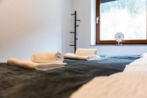 two towels sitting on top of a bed with a window at Vila Hrastnica in Škofja Loka