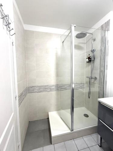 une douche avec une porte vitrée dans une salle de bain dans l'établissement Modern Home proche de Disneyland et Paris, à Champs-sur-Marne