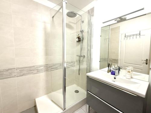 a white bathroom with a shower and a sink at Modern Home proche de Disneyland et Paris in Champs-Sur-Marne