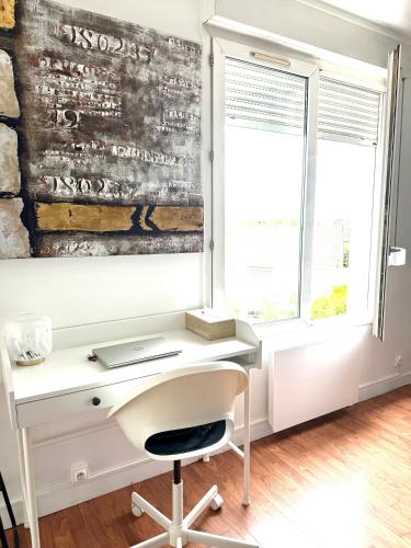 - un bureau blanc avec un ordinateur portable placé à côté d'une fenêtre dans l'établissement Modern Home proche de Disneyland et Paris, à Champs-sur-Marne