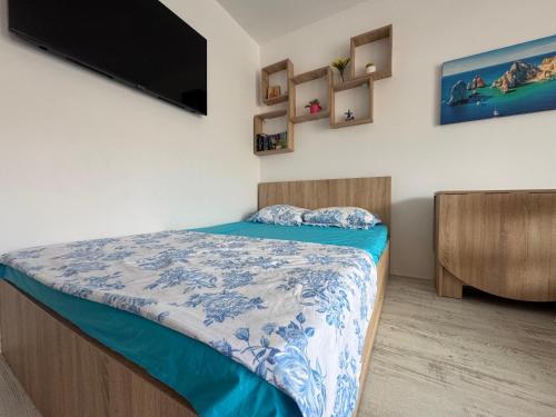 ein Schlafzimmer mit Bett und Flachbildfernseher in der Unterkunft Saturn SunRise Studio in Saturn