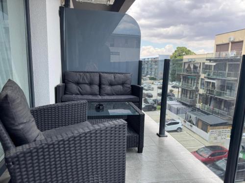 einen Balkon mit zwei Stühlen und einer Couch auf einem Gebäude in der Unterkunft Saturn SunRise Studio in Saturn
