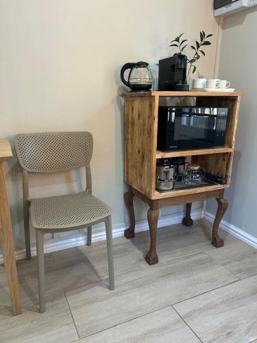 a wooden table with a chair and a television at The Blossom Room in Robertson