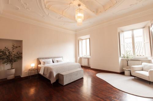 a white bedroom with a bed and a couch at Le Stonghe City Apartment in Fossombrone