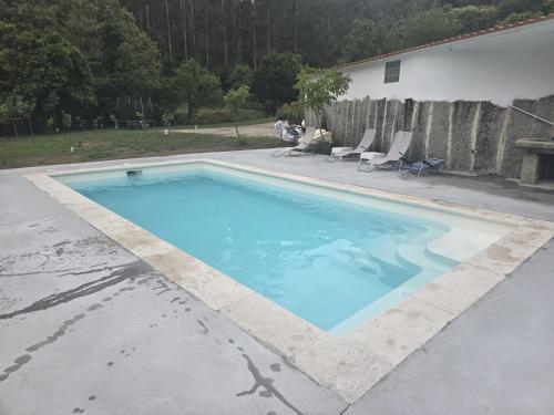a swimming pool in a yard with two chairs at CASITA RECIEN HABILITADA A ESTRENAR CON PISCINA EN MALVAS Tuy in Malvas