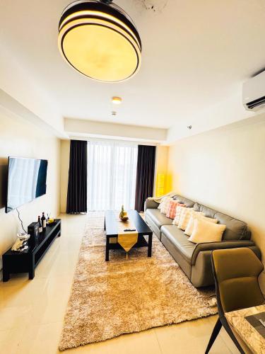 a living room with a couch and a table at Luxury Penthouse & High-Floor Hotel near City of Dreams, Airport, Okada, and Solaire Casino in Manila