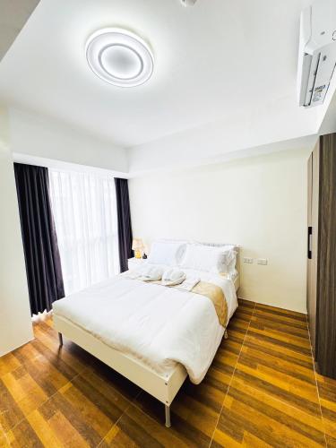 a bedroom with a large white bed in a room at Luxury Penthouse & High-Floor Hotel near City of Dreams, Airport, Okada, and Solaire Casino in Manila