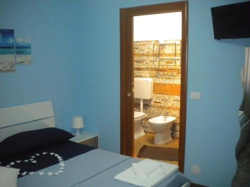 a bedroom with a bed and a bathroom with a toilet at B&B del Centro in Capo dʼOrlando