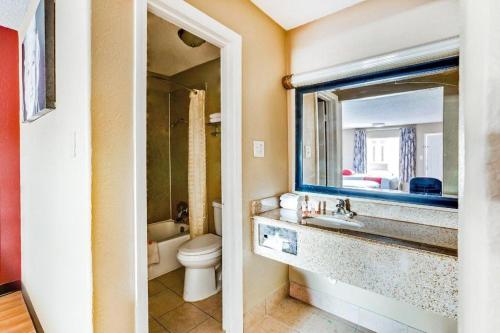 une salle de bain avec un lavabo, des toilettes et un miroir dans l'établissement OYO Hotel Tyler Northwest Mineola Hwy, à Tyler