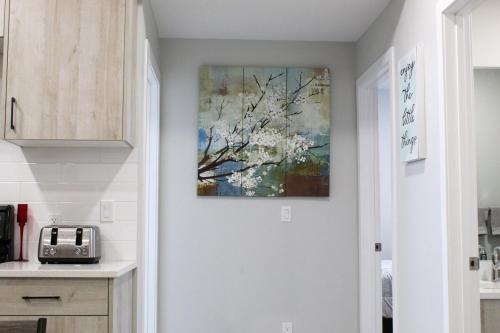 a kitchen with a painting on the wall at Cozy 2-Bedroom Walkout Basement Suite in Calgary
