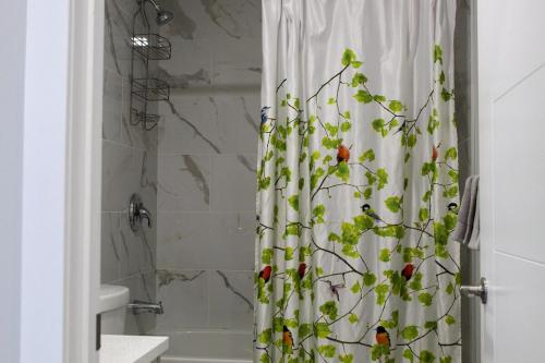 a bathroom with a shower curtain with a plant at Cozy 2-Bedroom Walkout Basement Suite in Calgary