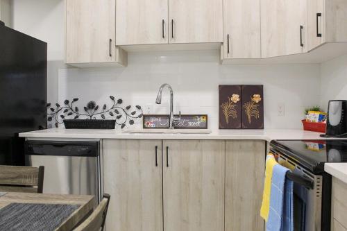 a kitchen with white cabinets and a counter top at Cozy 2-Bedroom Walkout Basement Suite in Calgary