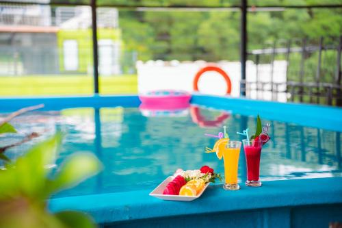 a plate of food and drinks next to a swimming pool at Crystal Holiday Ha Long Hotel in Ha Long